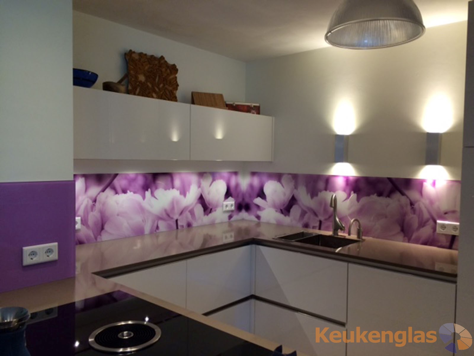 Witte glazen keukenwand met zwarte bloemversiering keukenglas